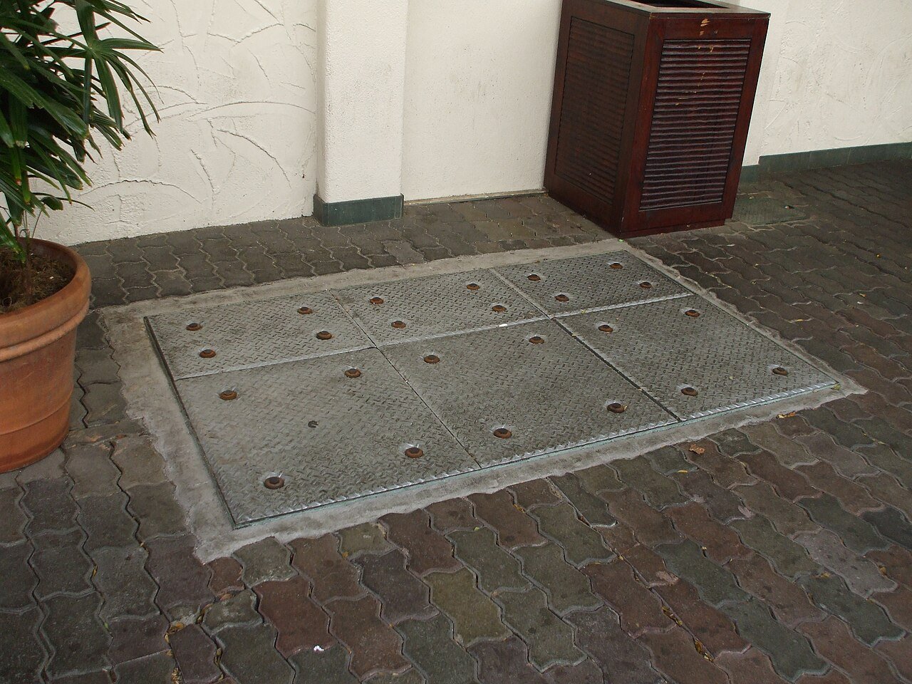 Open manhole lids of an in-ground grease trap outside a ramen restaurant